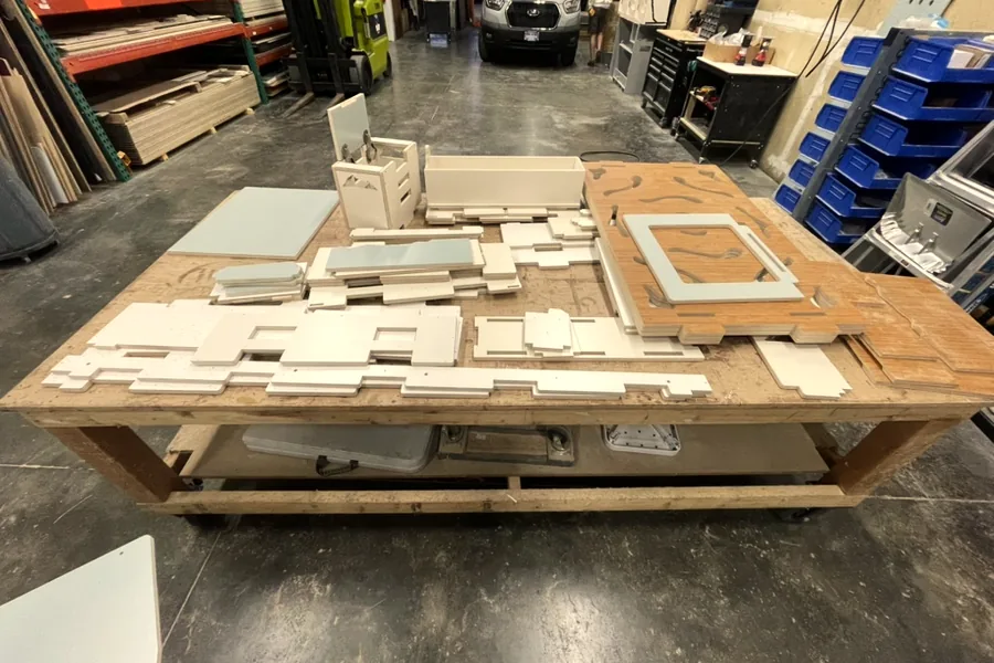 Flat-pack camper panels laid out on the shop bench